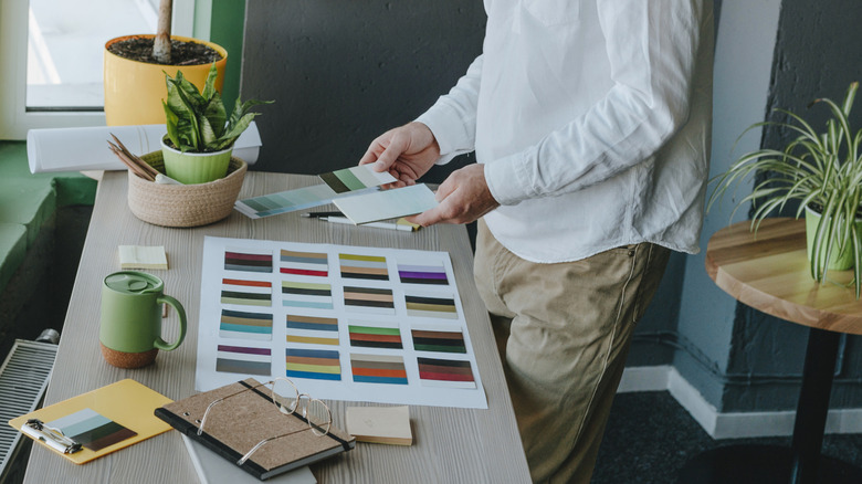 A man reviews color swatches while deciding how to decorate a room.