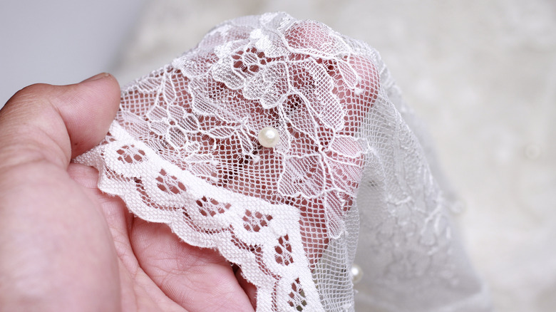 A person holding lace fabric