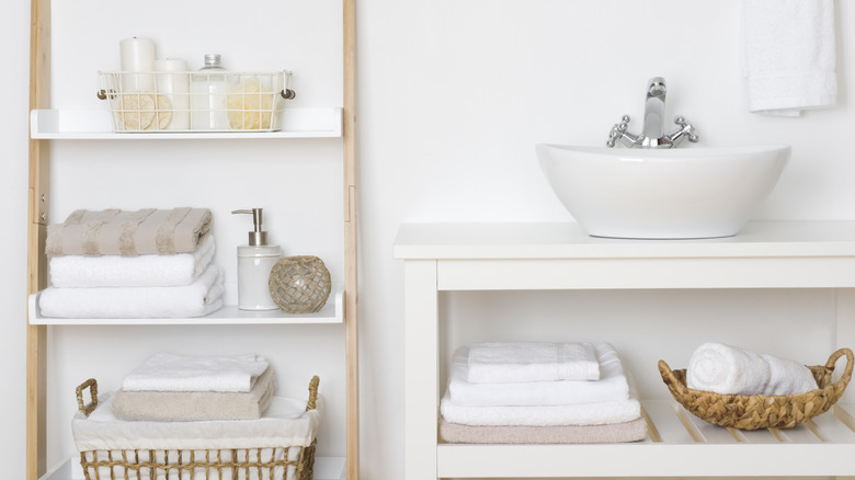 White decorative bathroom shelves with various toiletry items