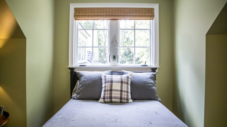 Bedroom with Roman shade pulled up to let sunlight through the window