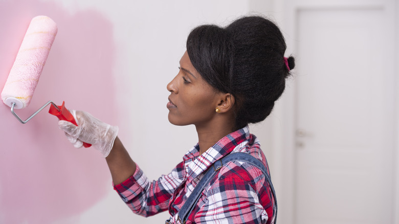 woman painting with roller