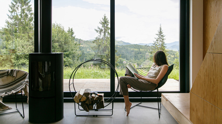 Woman relaxing in front of large window.