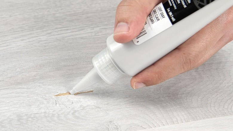 Filling in a scratch on laminate floor using repair putty
