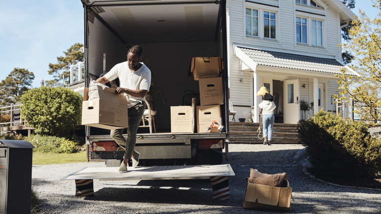 A person moving boxes into a moving truck