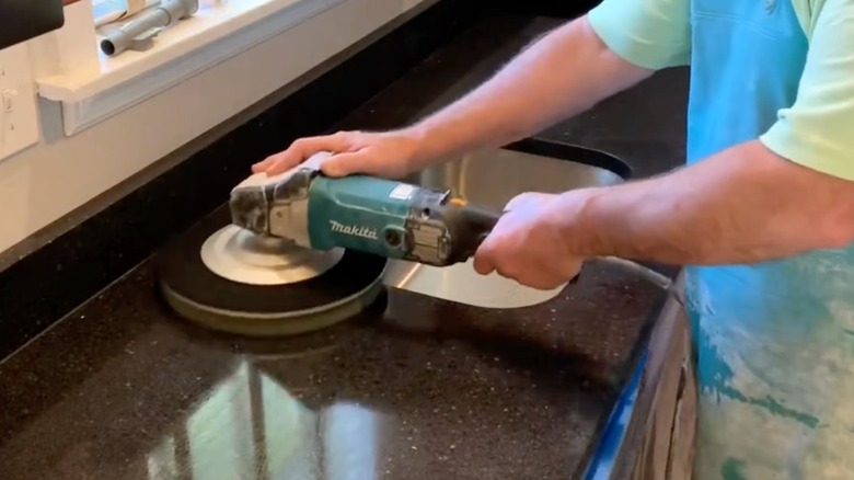 Person using a grinder and polishing pad to buff quartz countertop