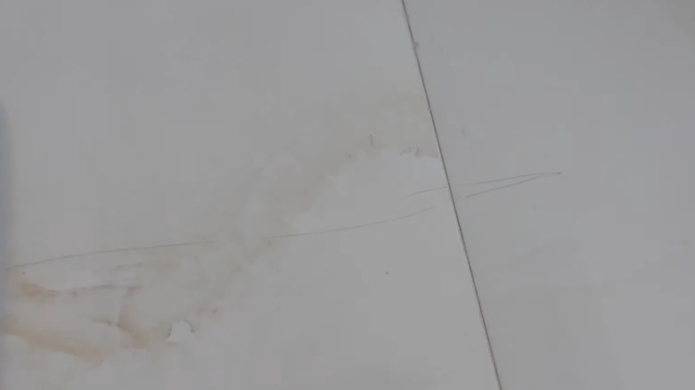 Close up of a scratch on white ceramic tile