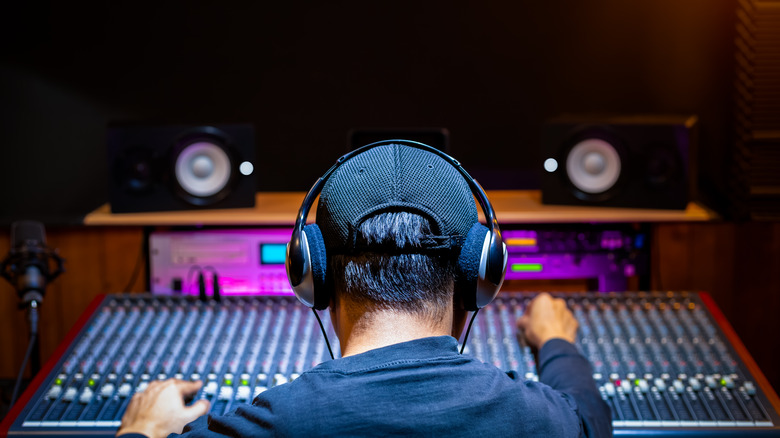 Producer with headphones and monitors