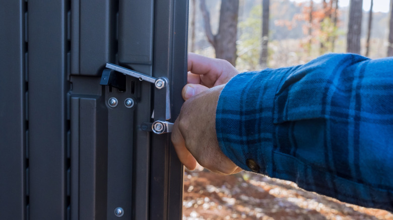 Person using lock on outdoor shed