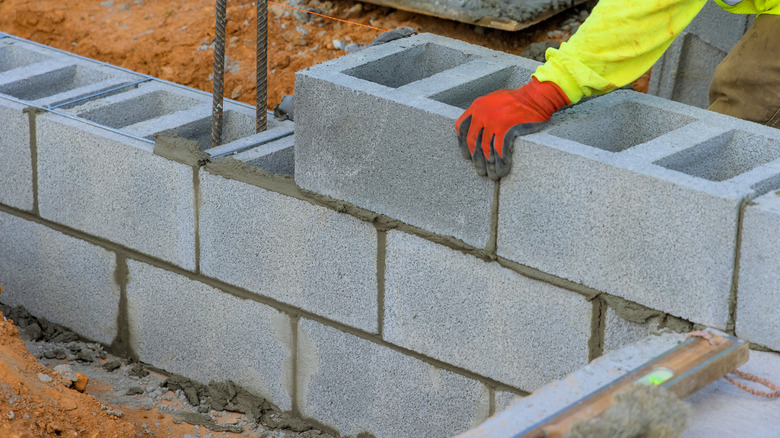 Person is building wall with concrete blocks