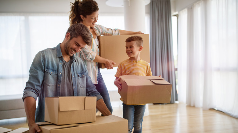 Family holding moving boxes