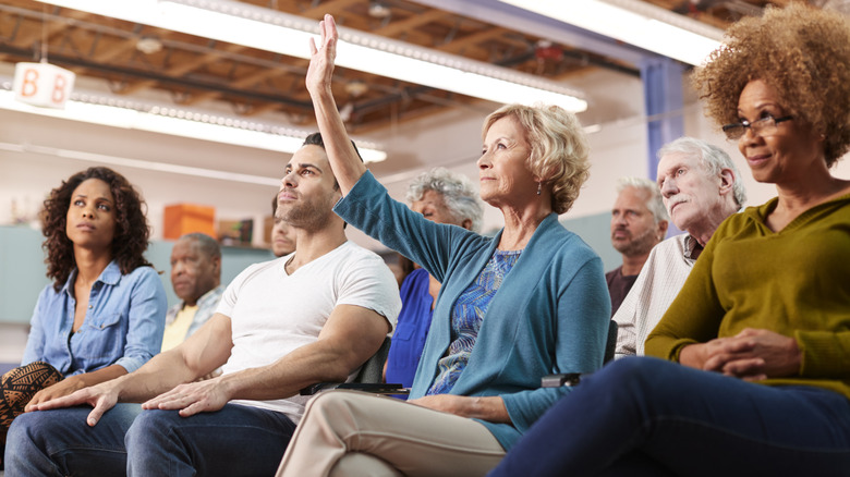 Woman raising her hand at a community gathering