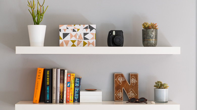 White floating shelves with books and plants