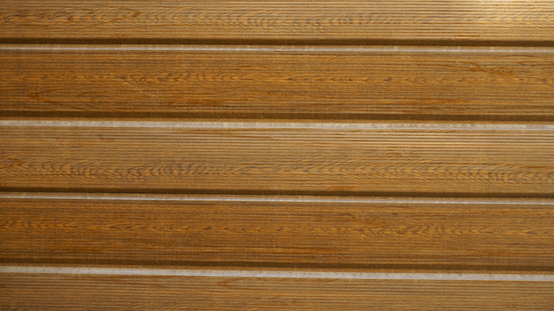 Brown faux wood exterior panel siding on wall.
