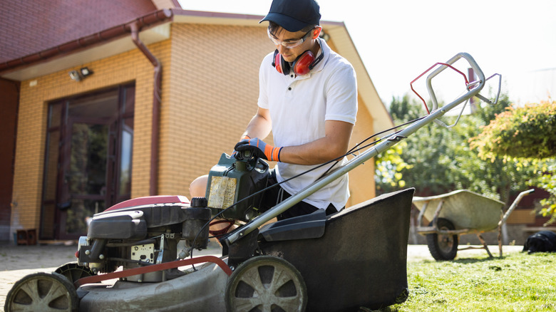 A man filling a lawn mower with gasoline