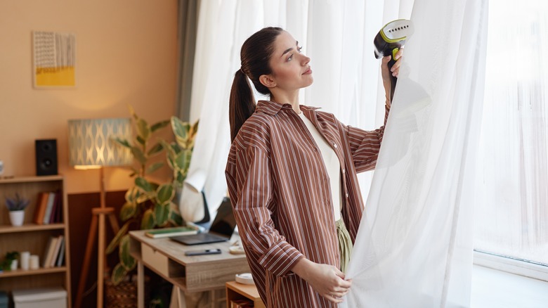 Woman cleaning curtain