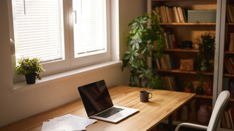 A home office with a desk in front of a window