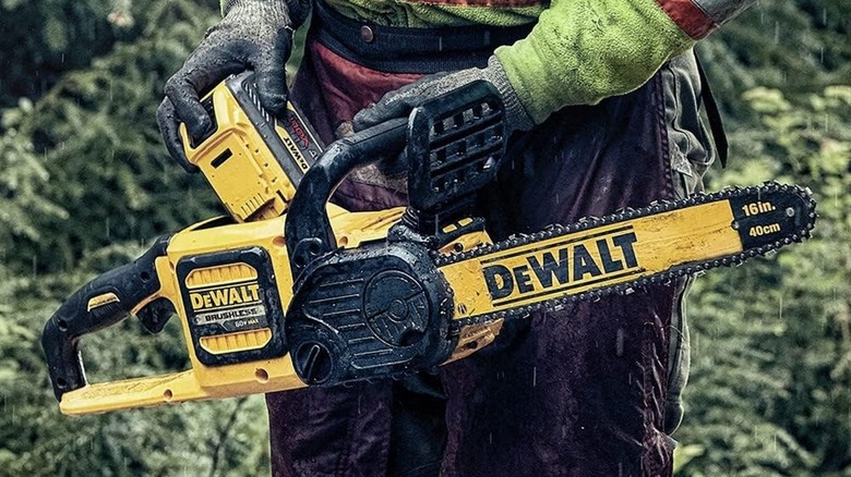 Person inserting a battery in a DeWalt 16-inch chainsaw