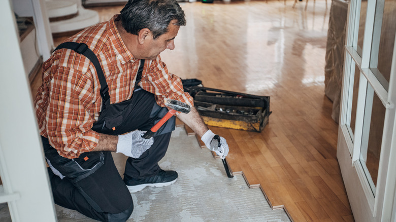 man installing hardwood flooring