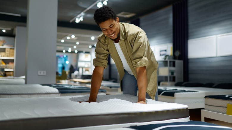 Smiling man mattress shopping