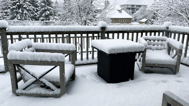 A front patio with furniture that has been covered in snow
