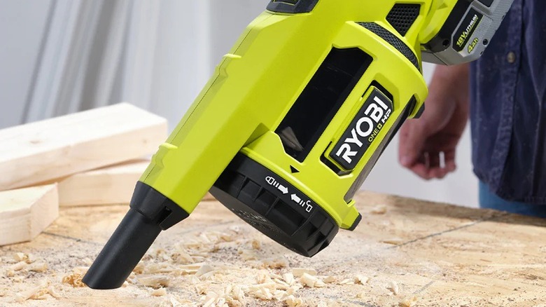 Person using Ryobi hand vacuum for cleaning sawdust