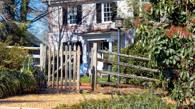 White colonial house with brick and pea gravel walkway