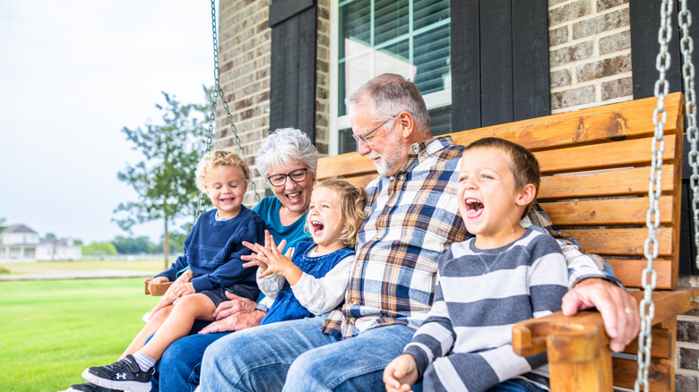 A happy family sitting on a patio swing.