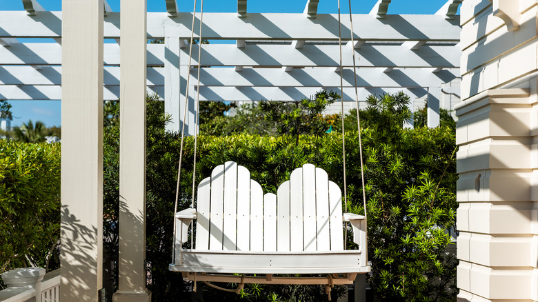 A white, wood patio swing.