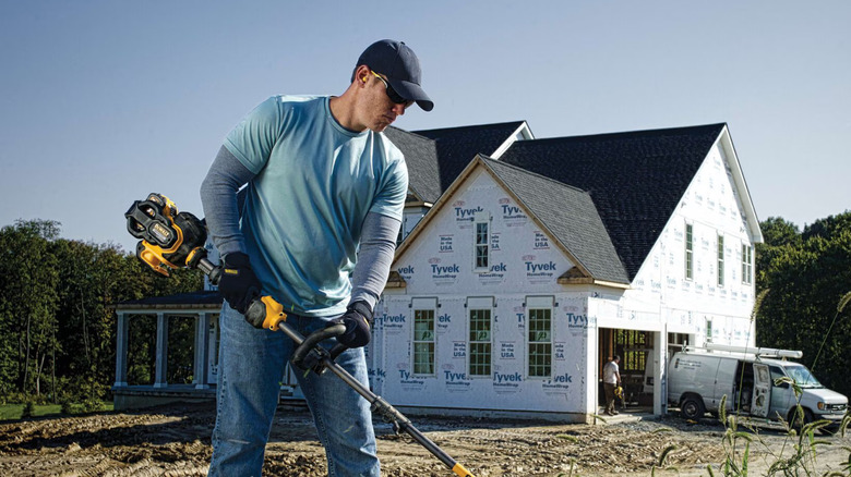 A man using DeWalt's 60V Max string trimmer