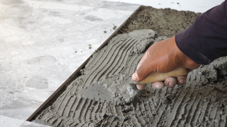 Person placing tile adhesive