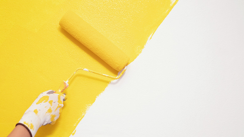 rolling yellow paint on wall