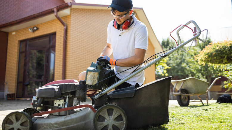 A man filling a lawn mower with gasoline