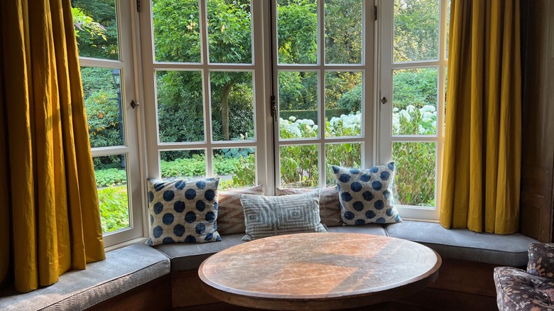 room with large bay windows and short curtains