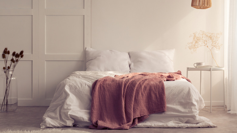 Queen bed with a pink throw blanket