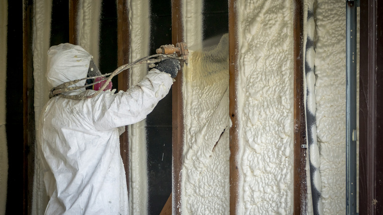 Person applying spray foam insulation