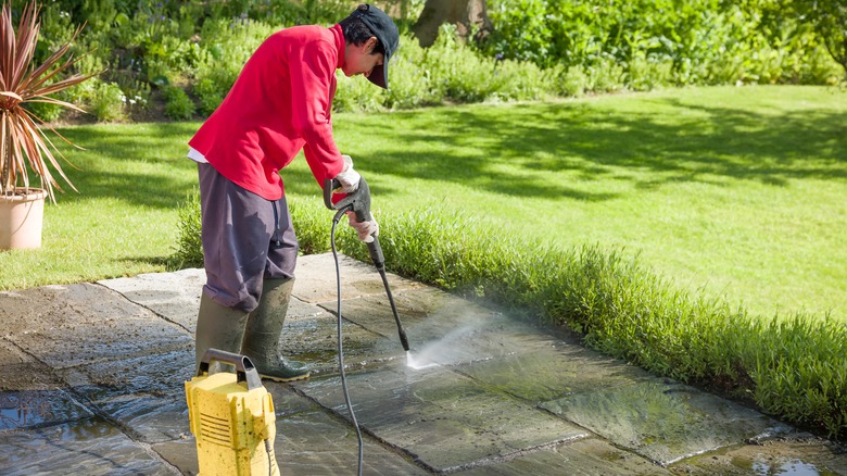 person power-cleaning concrete 