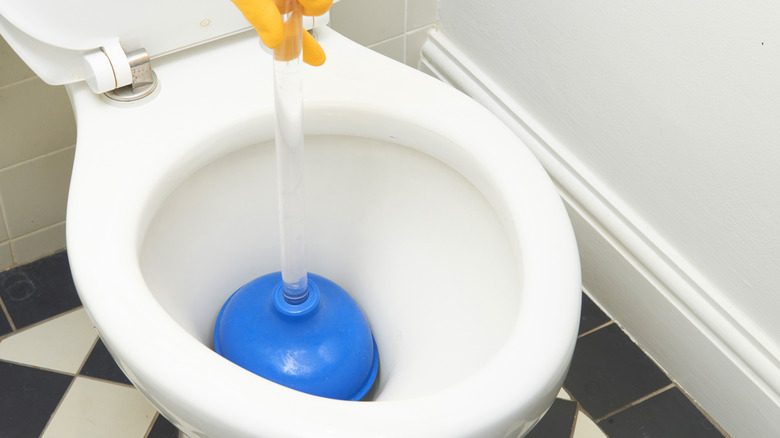 Using a plunger to unclog a toilet