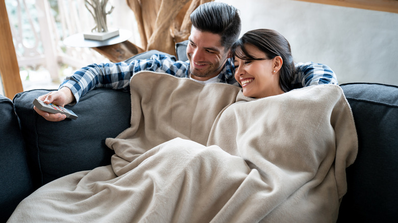 A couple snuggled under a blanket