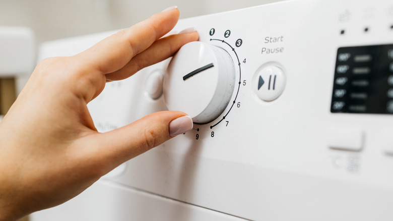 woman setting the wash cycle on washing machine