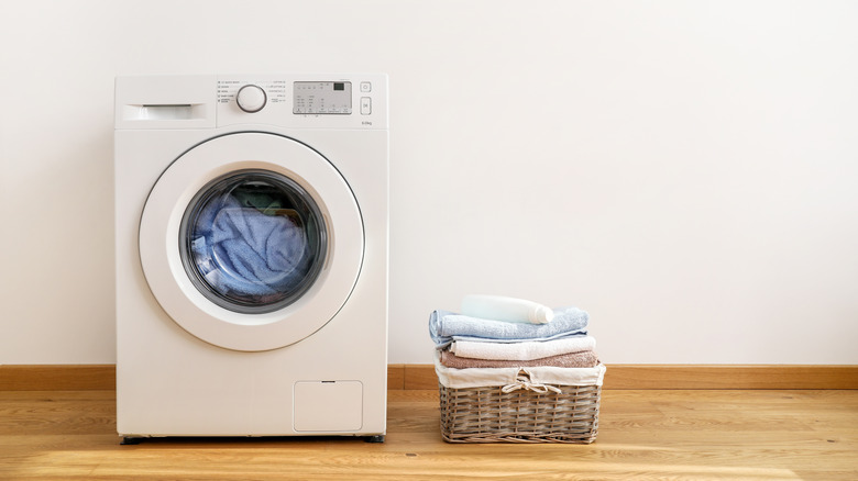 washing machine next to a basket of towels