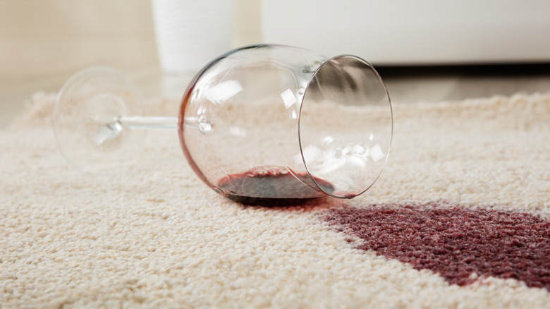 Spilled glass of red wine on a white carpet