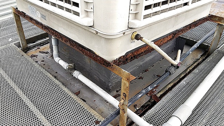 The bottom of an AC unit with a connected drain line