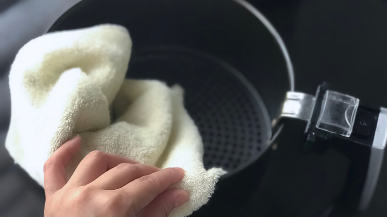 Wiping an air fryer basket clean