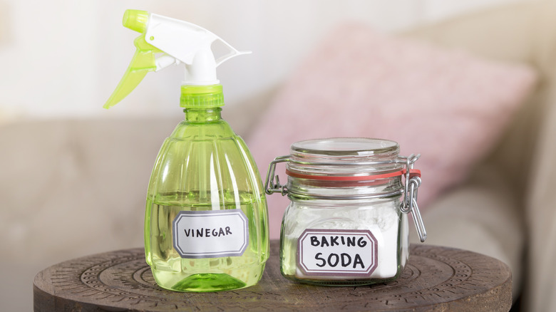 Spray bottle of vinegar and container of baking soda