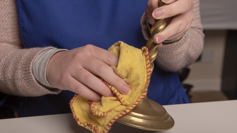 Hands clean brass candlestick