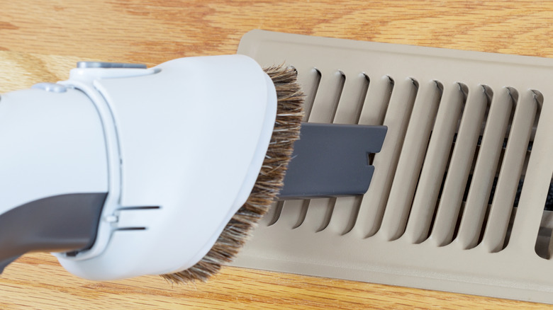 Close-up of a brush cleaning a floor register