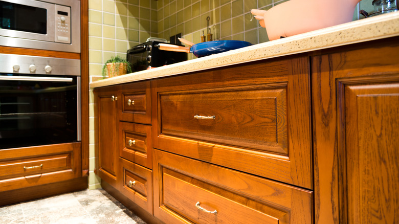 Kitchen with wood cabinets and wood surrounding built-in appliances.