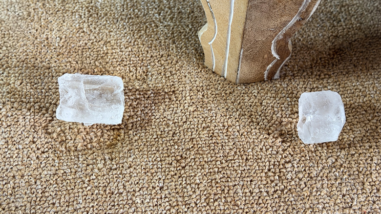 Ice cubes on a brown carpet.