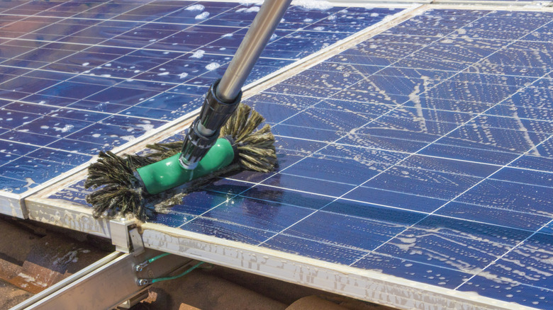 A mop cleaning blue solar panels