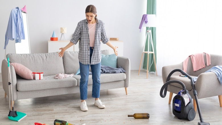 Frustrated woman in messy apartment